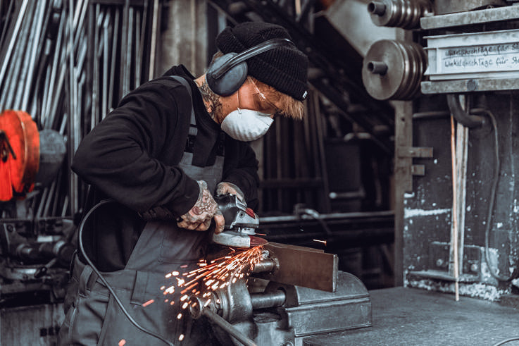 Erfinder vom mobilen Skateboardstuhl. Arbeit mit Winkelschleifer 